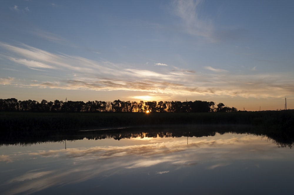 the sun is setting over a body of water