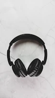 Close-up of elegant headphones resting on a black velvet surface with champagne highlights.