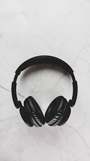 Close-up of elegant headphones resting on a black velvet surface with champagne highlights.