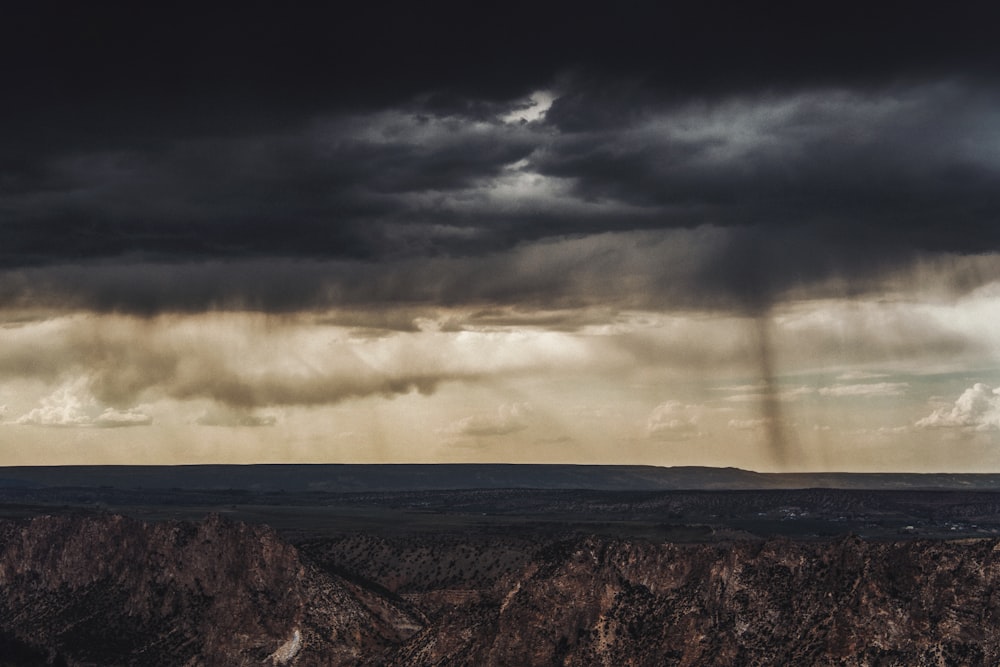 a dark cloud hangs over a mountain range