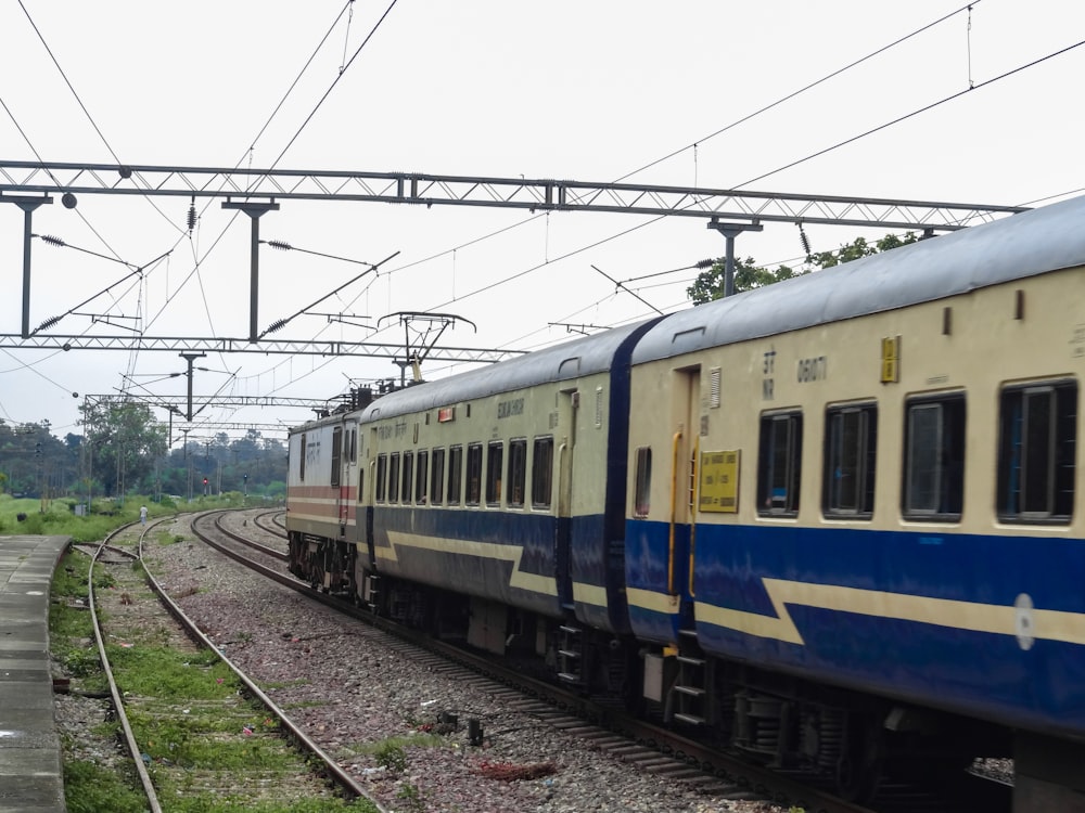 a blue and white train traveling down train tracks