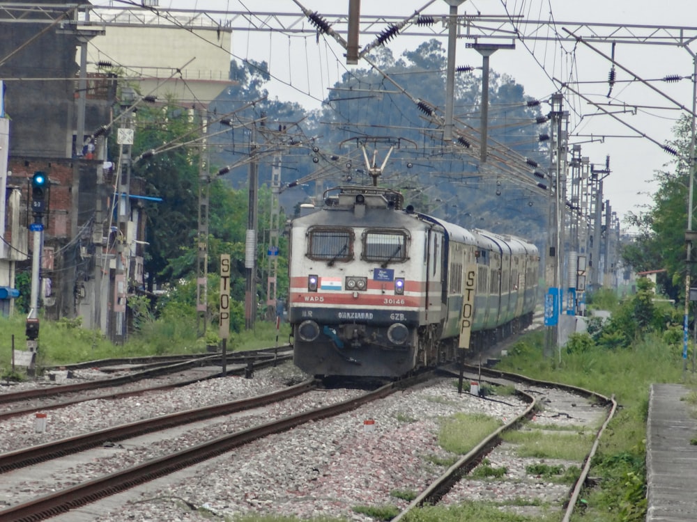 a train traveling down train tracks next to a forest