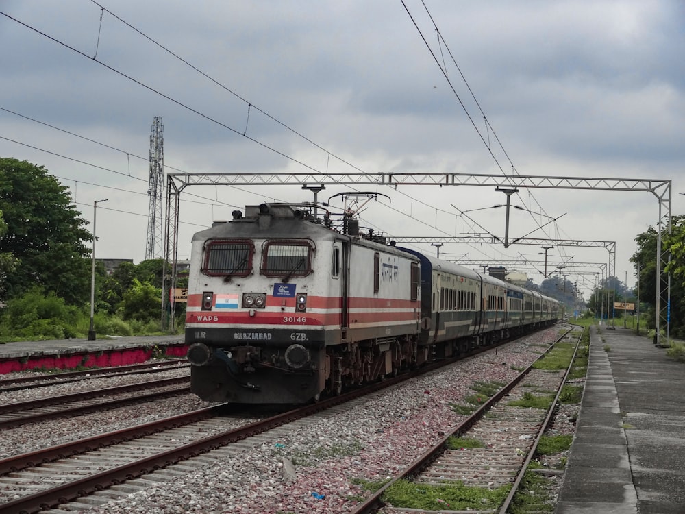 a train traveling down train tracks next to a forest