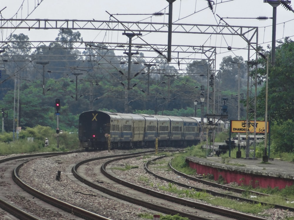 a train traveling down train tracks next to a forest