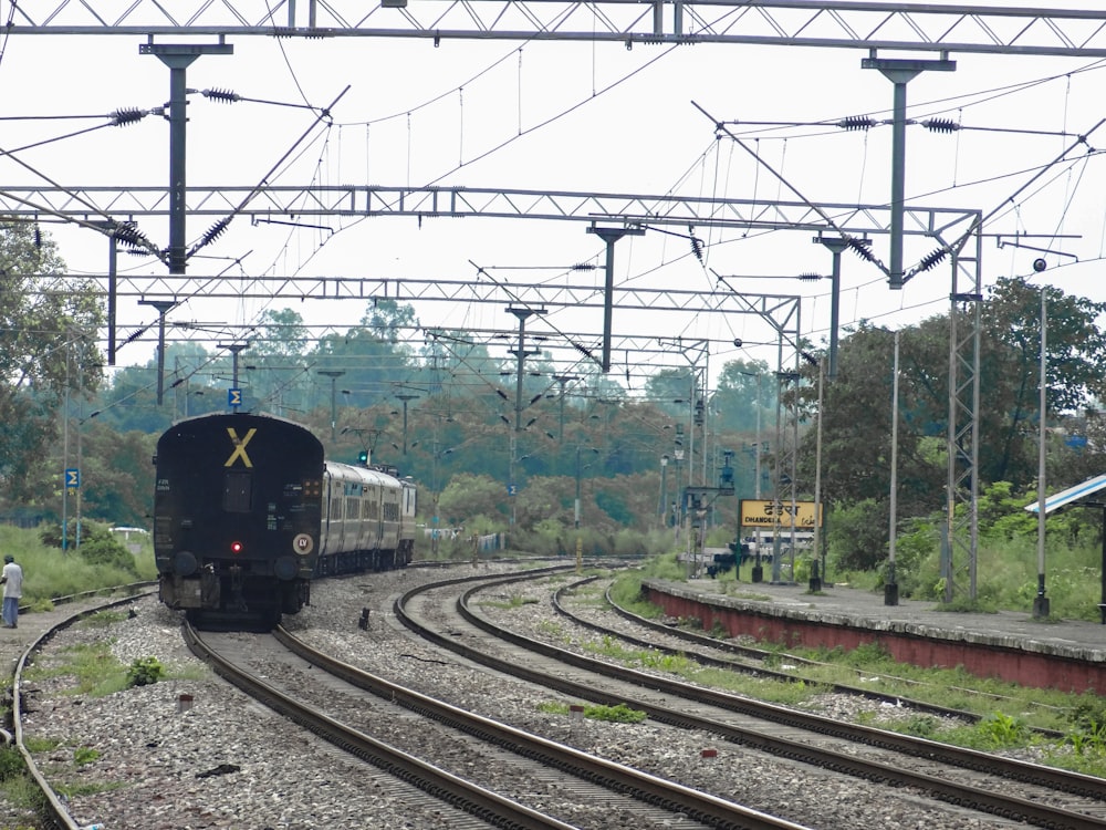 a train traveling down train tracks next to a forest