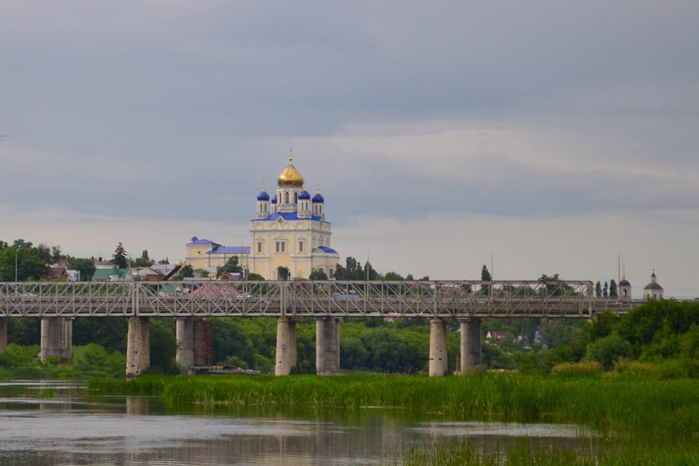 a bridge over a body of water with a church in the background