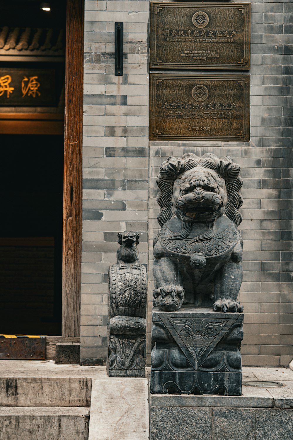 a statue of a lion on a pedestal in front of a building