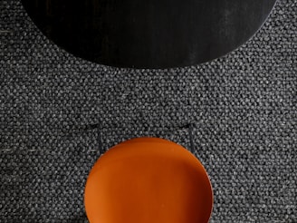 an orange plate sitting on top of a black table
