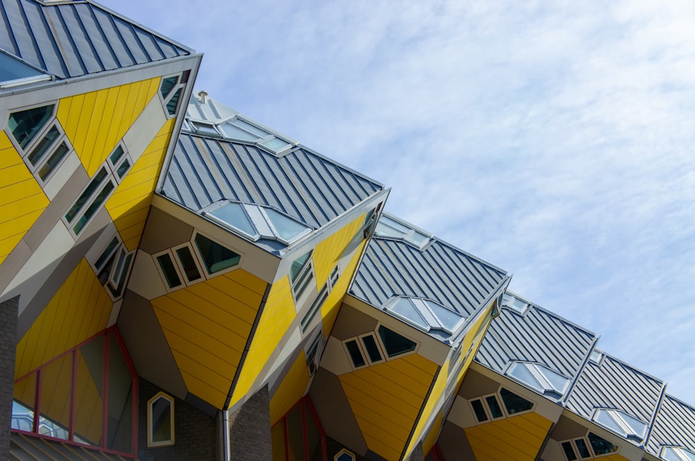 a row of yellow and grey buildings against a blue sky