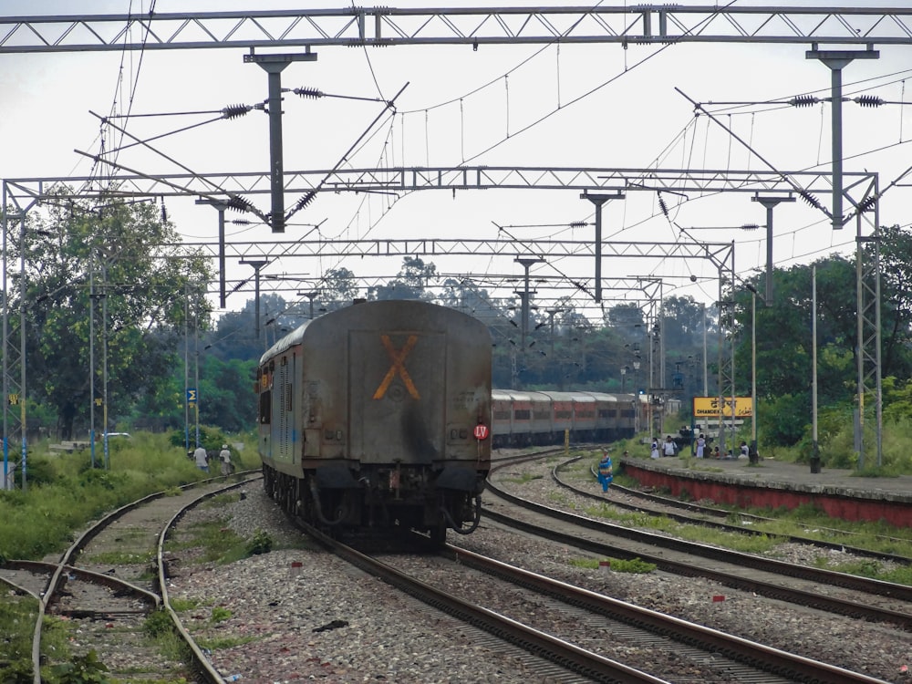 a train traveling down train tracks next to a forest