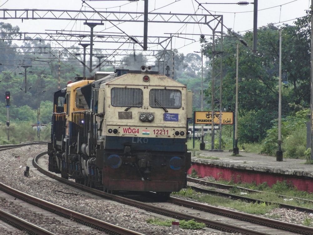 a train traveling down train tracks next to a forest