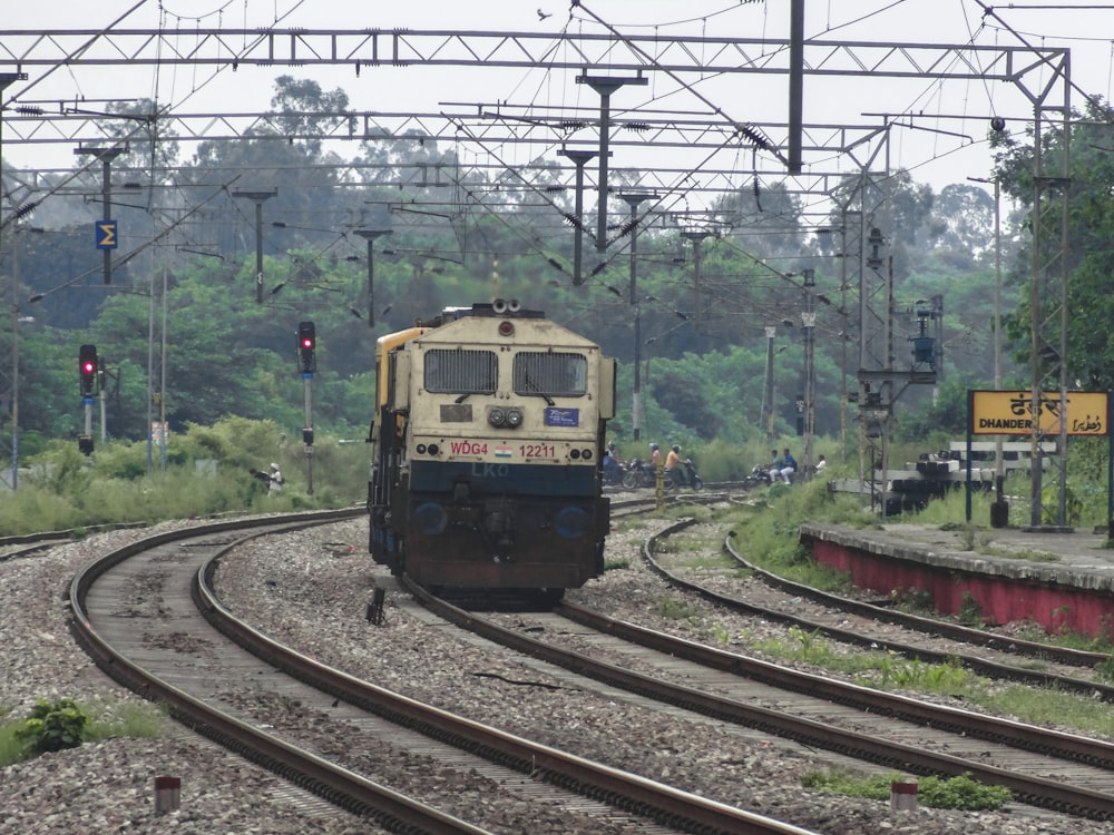 a train traveling down train tracks next to a forest