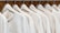 A row of identical light-colored sweaters is neatly hung on wooden hangers against a wooden background. Each sweater has a simple design with a round neckline and is labeled with the size 'M' and the brand 'Vintage Republic'. The arrangement is orderly, creating a sense of uniformity.