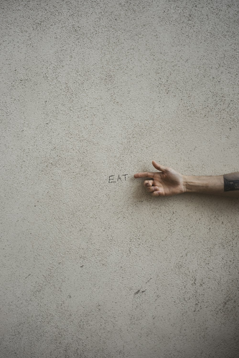 a person's hand pointing at the word eat