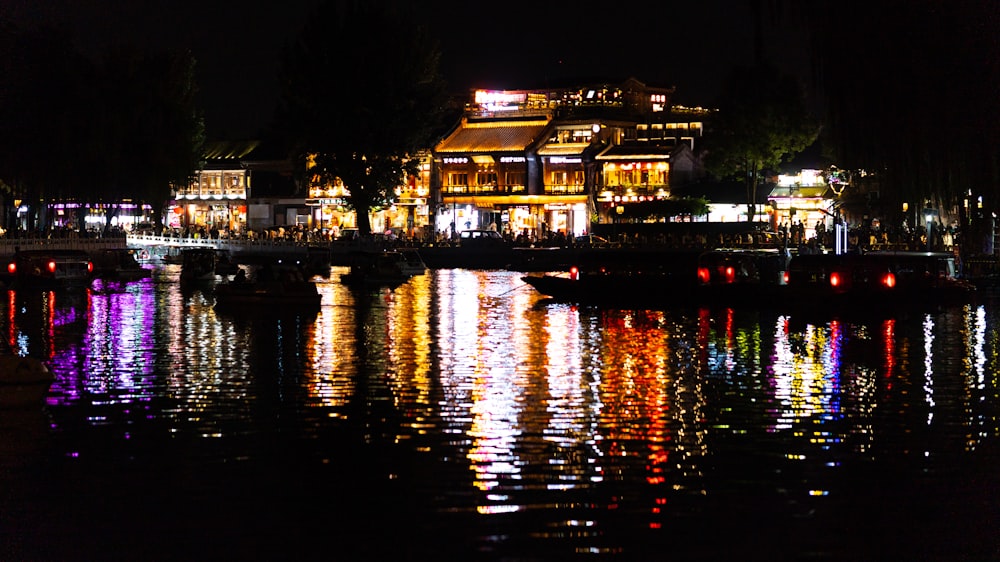 a house is lit up at night on the water