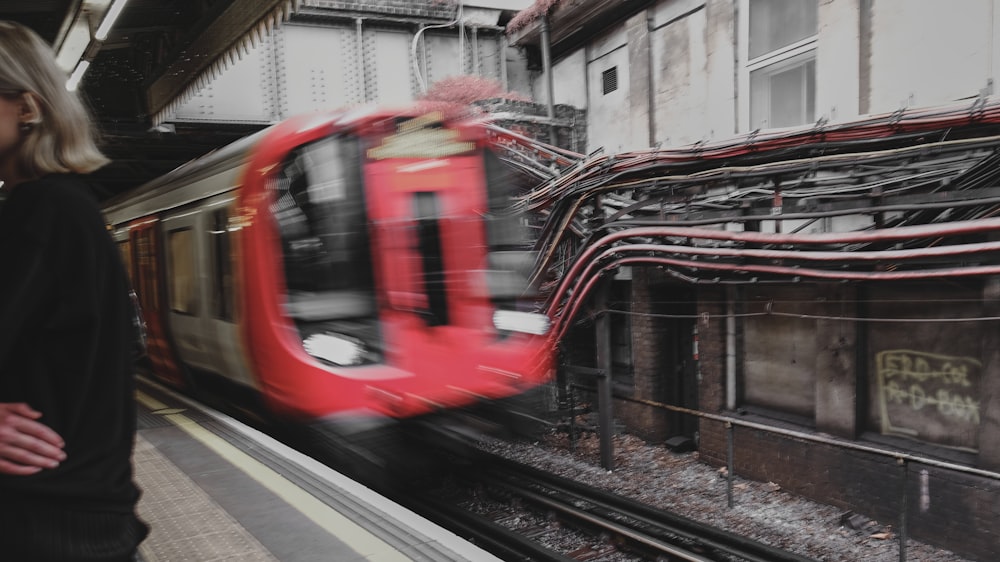 a woman standing next to a train on a train track