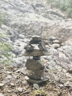 A balanced rock cairn on a serene natural background