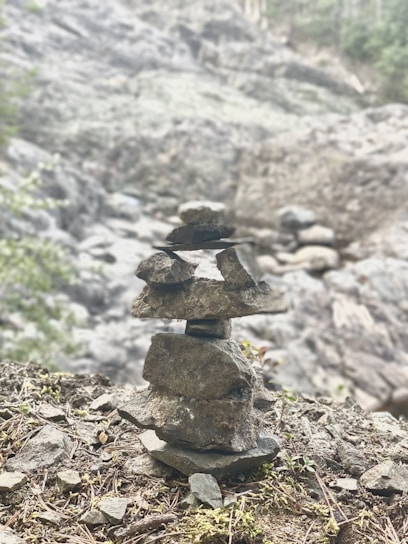 A balanced rock cairn on a serene natural background