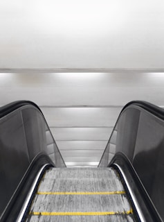 an escalator with a yellow line going down it