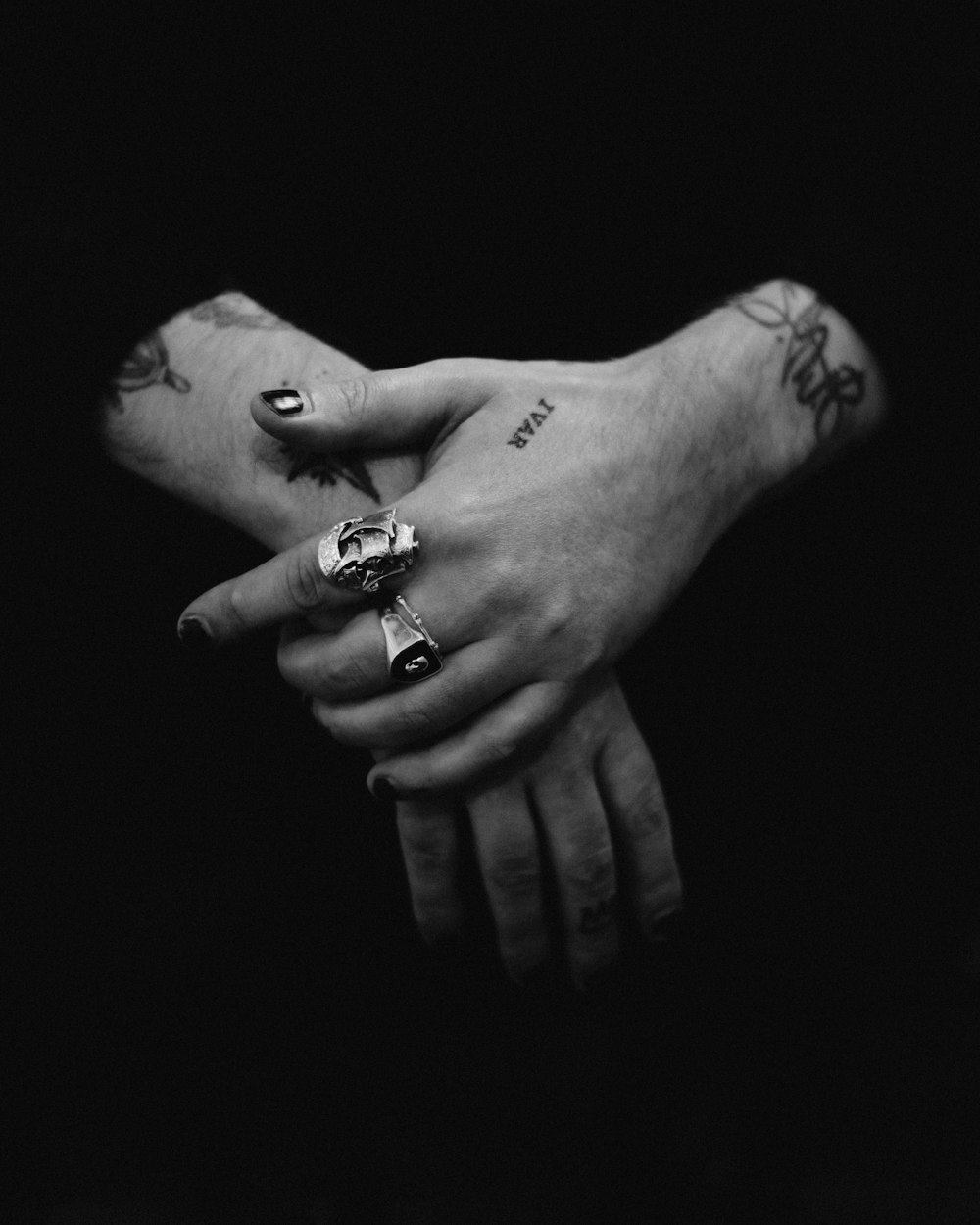 two hands holding each other with tattoos on them