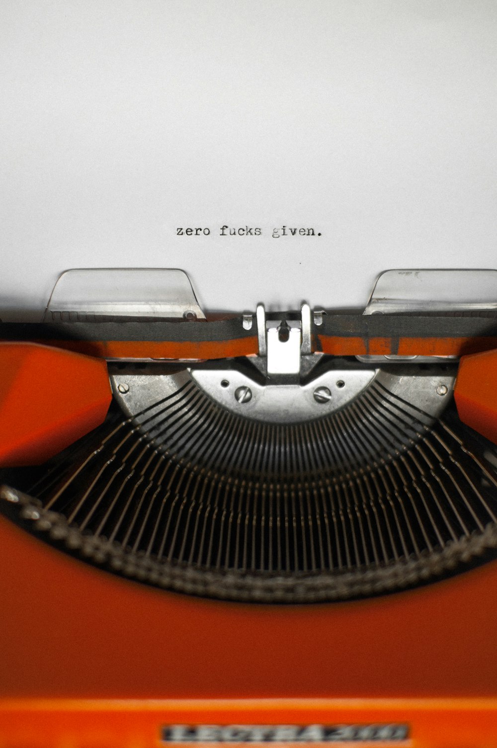 a close up of an orange typewriter
