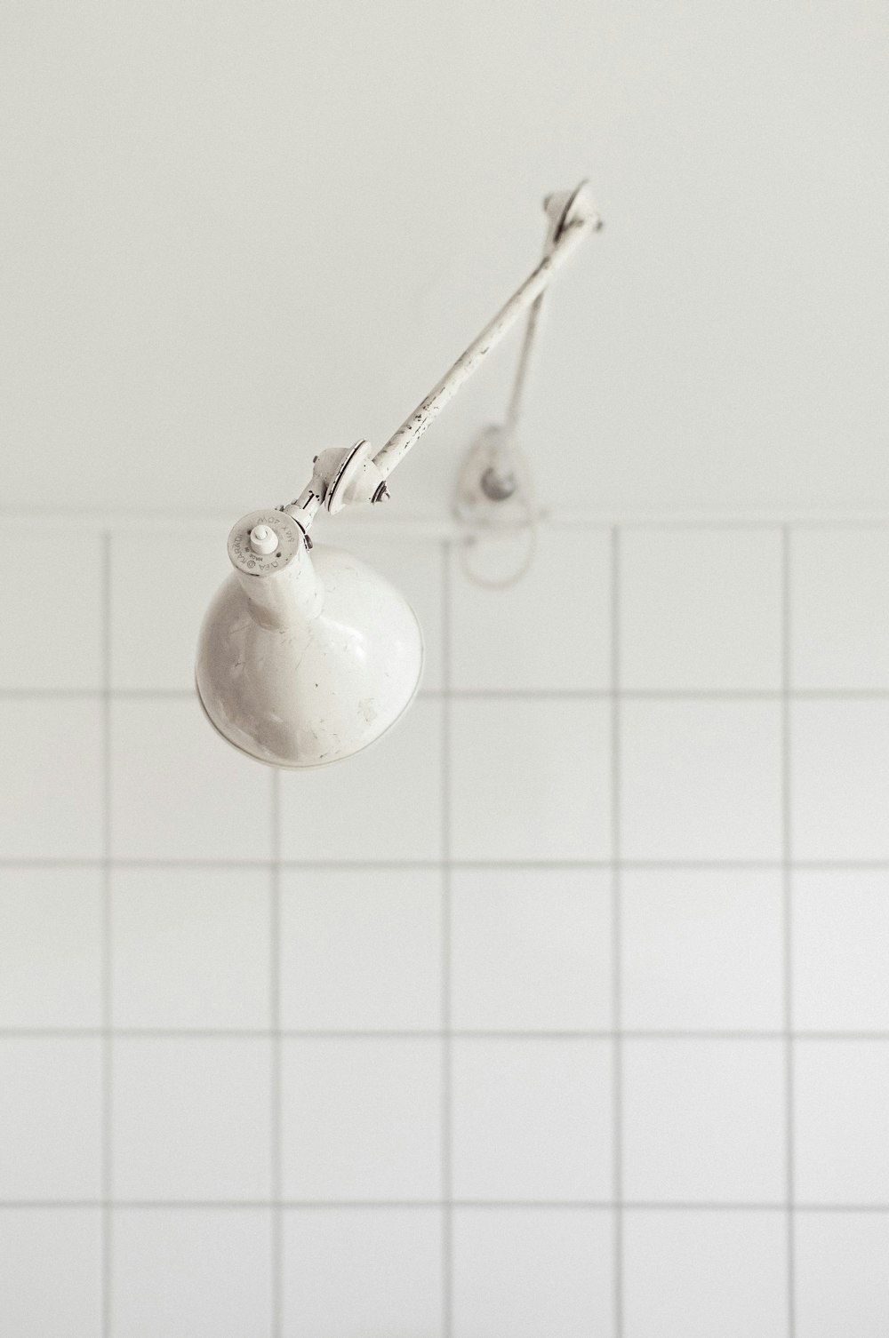 a bathroom with a white tiled wall and ceiling