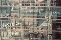 a building is reflected in the windows of another building