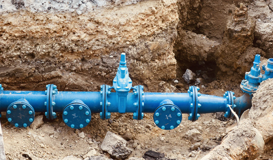 New water main with gate valves laid in an open trench before backfill