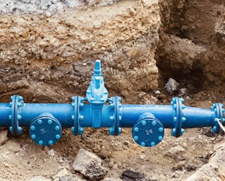 a blue pipe laying on top of a pile of dirt