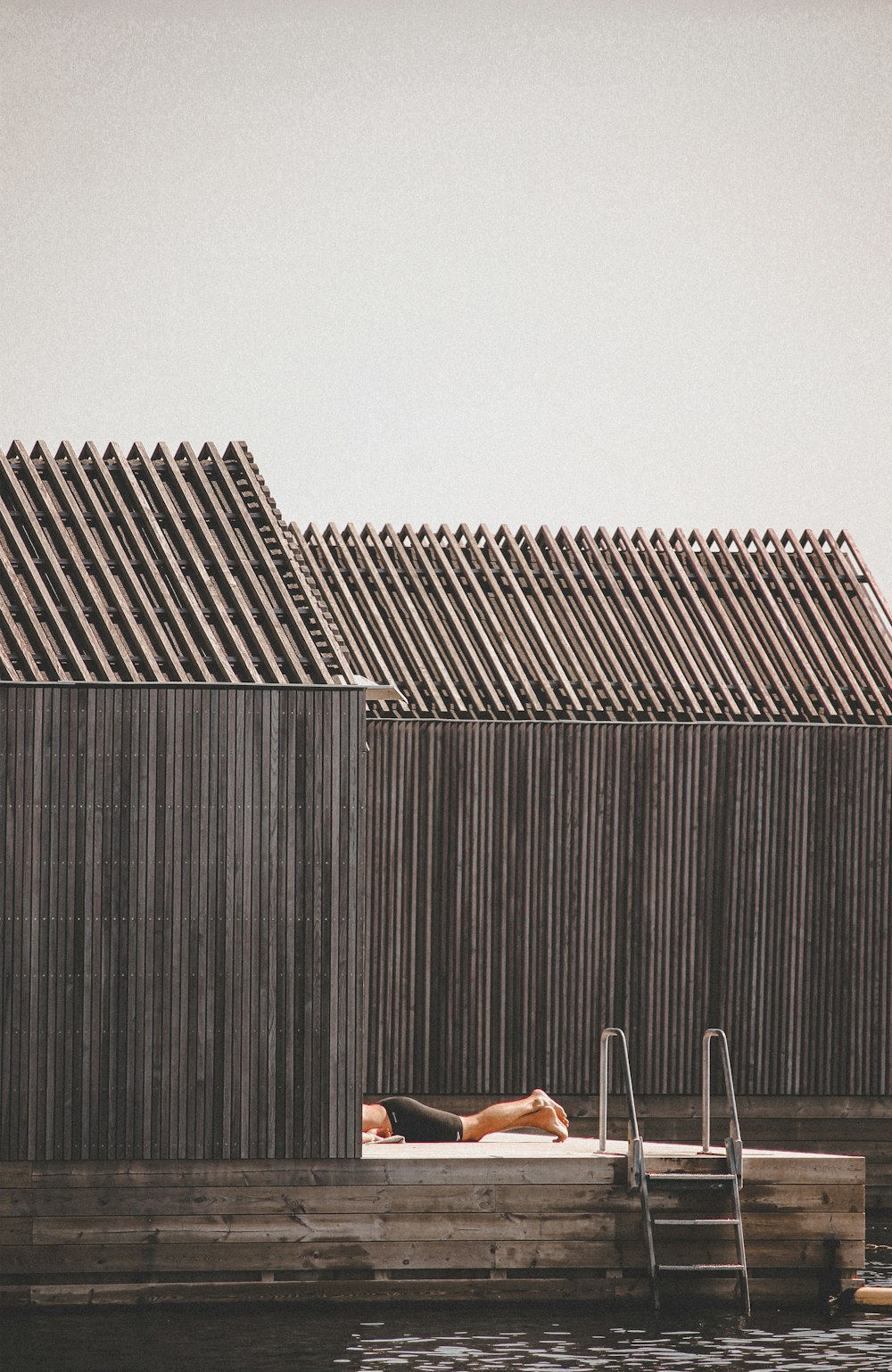 a person laying on a dock in front of a building