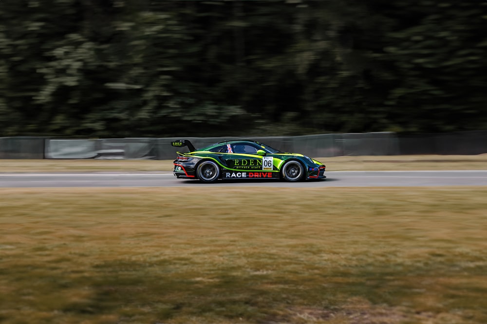 a car driving on a race track with trees in the background