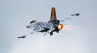 a fighter jet flying through a cloudy sky