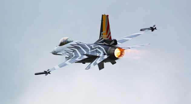 a fighter jet flying through a cloudy sky