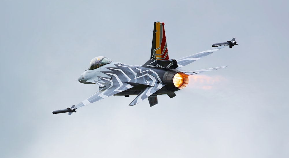 a fighter jet flying through a cloudy sky