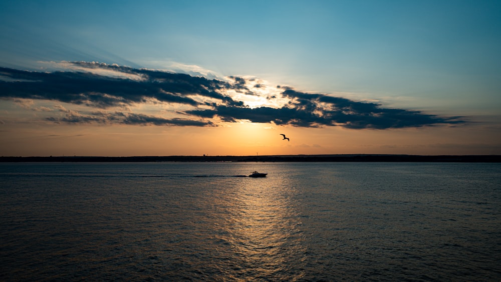 a boat in a body of water at sunset