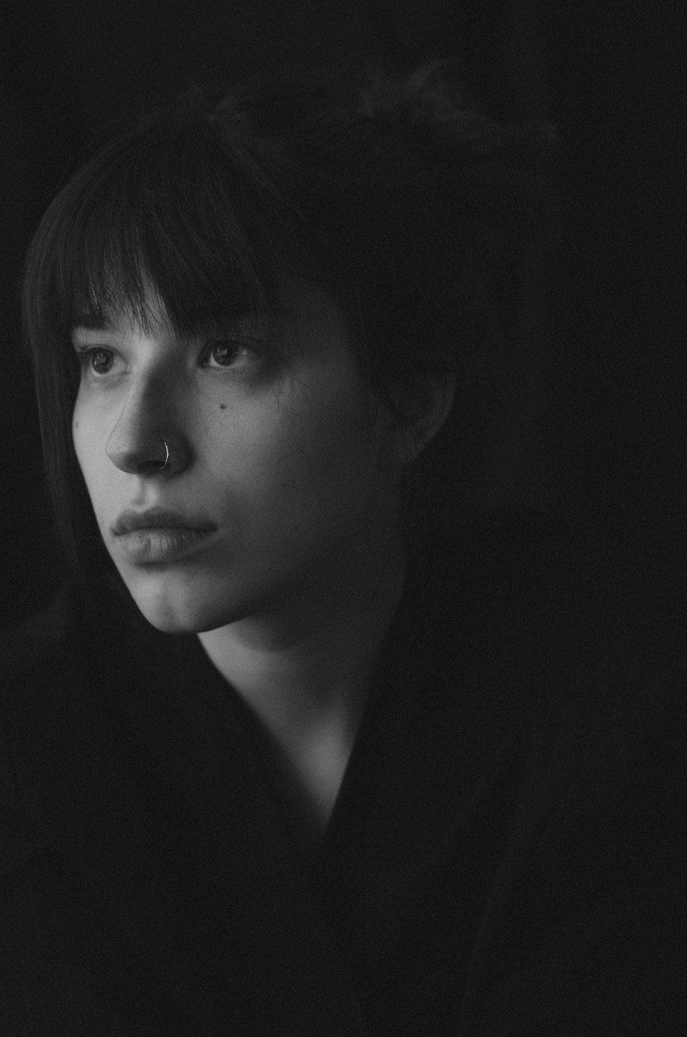 a black and white photo of a woman with bangs