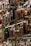 A collection of assorted liquor bottles displayed on glass shelves, arranged in a well-lit setting with a variety of shapes, sizes, and labels on the bottles. The shelves are crafted from reflective materials, enhancing the scarcity and selection of the spirits.