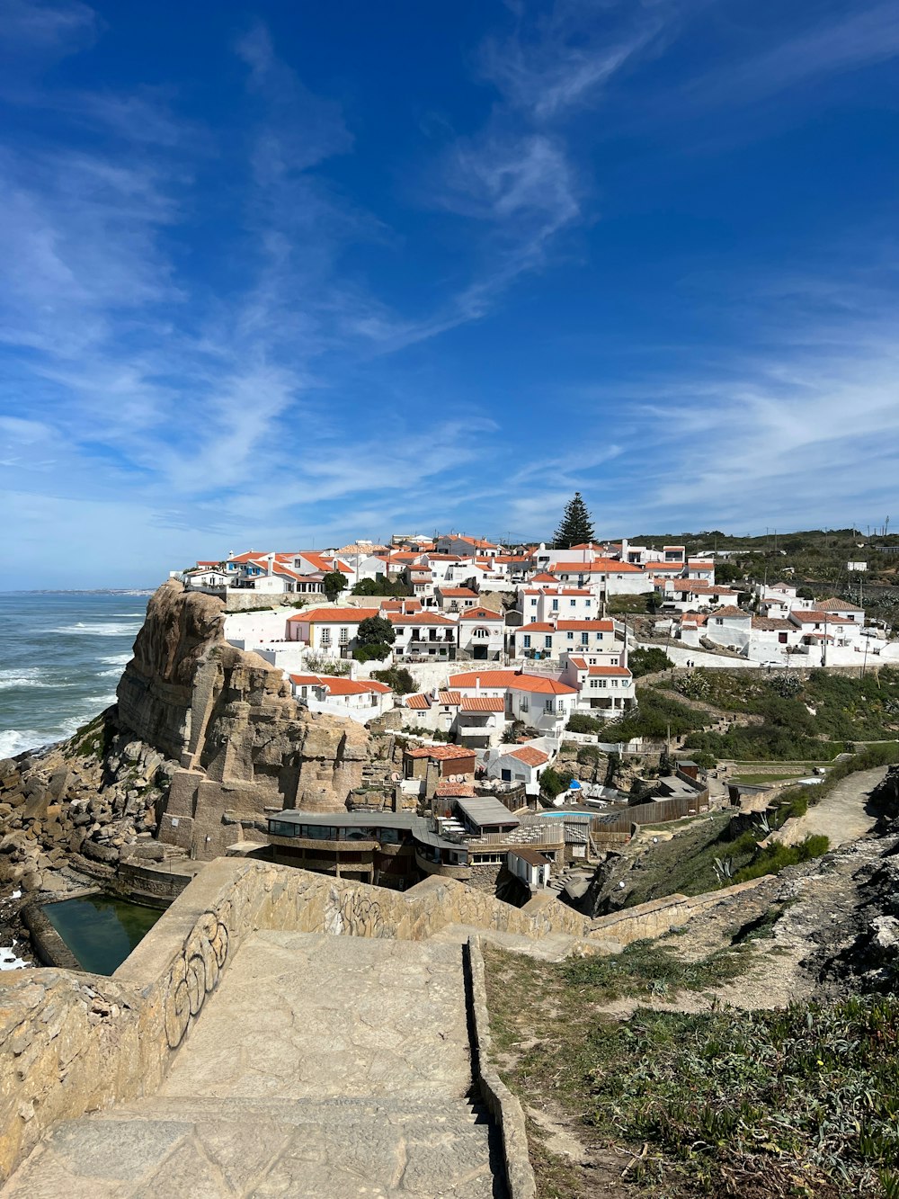 a scenic view of a small town on a cliff