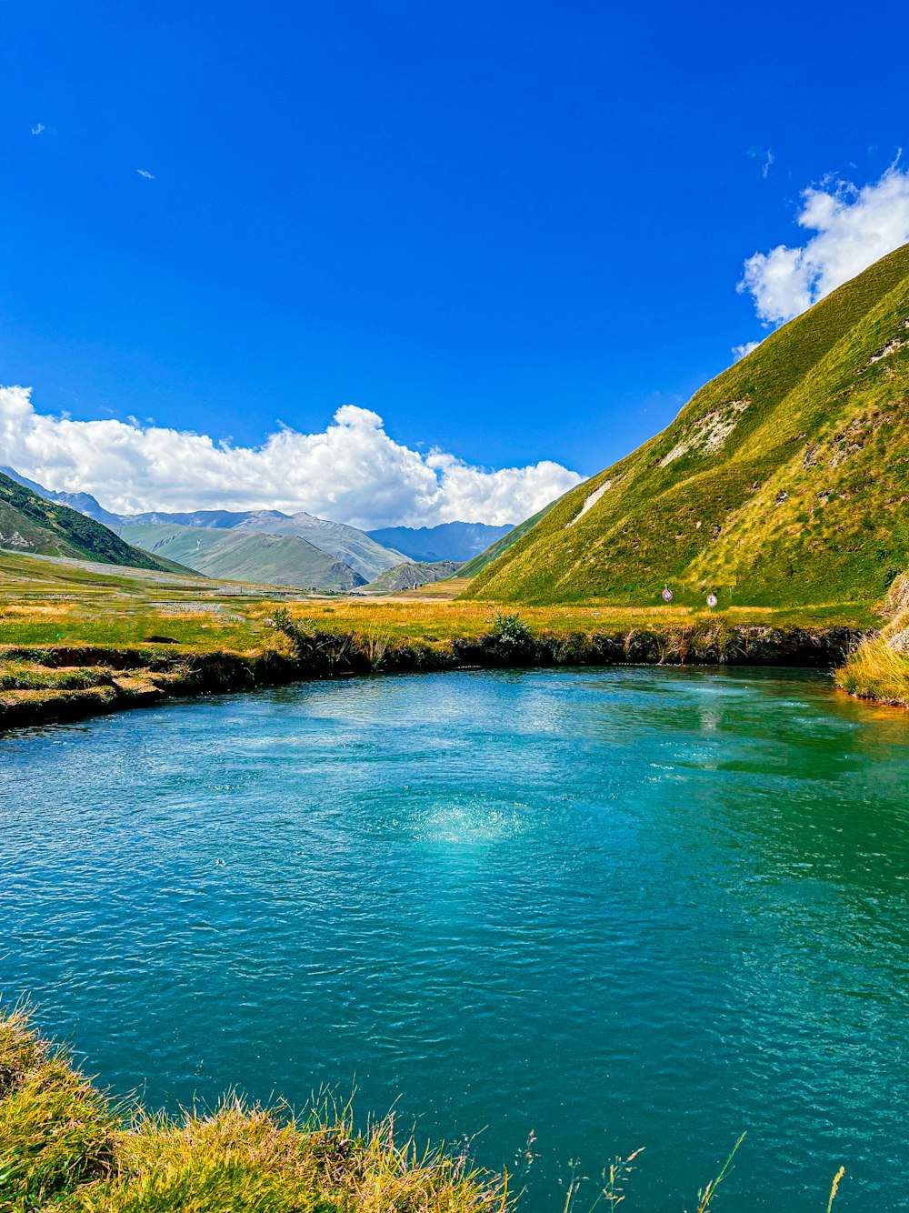 a river running through a lush green valley