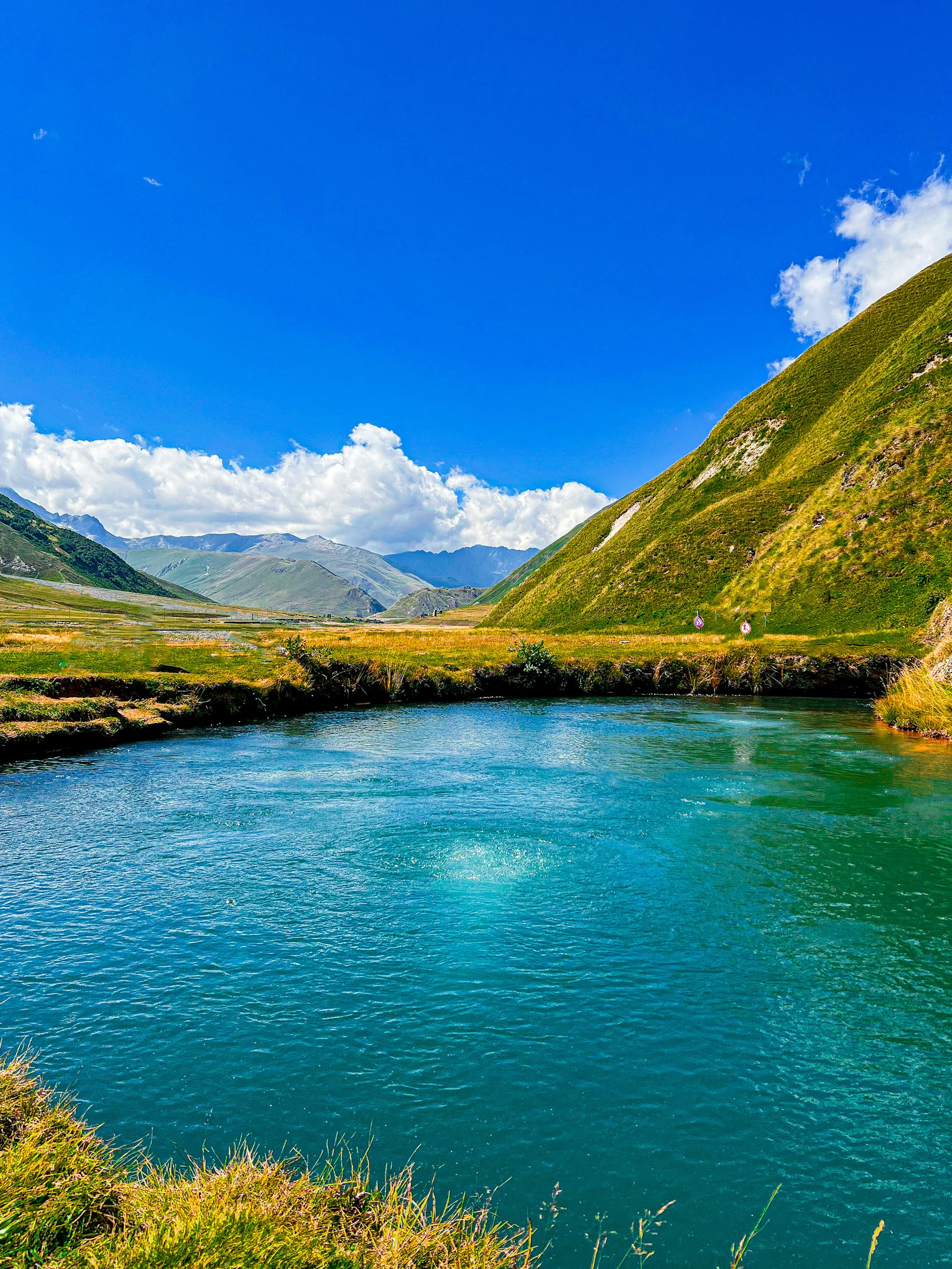 A serene landscape with a winding river under a clear blue sky.