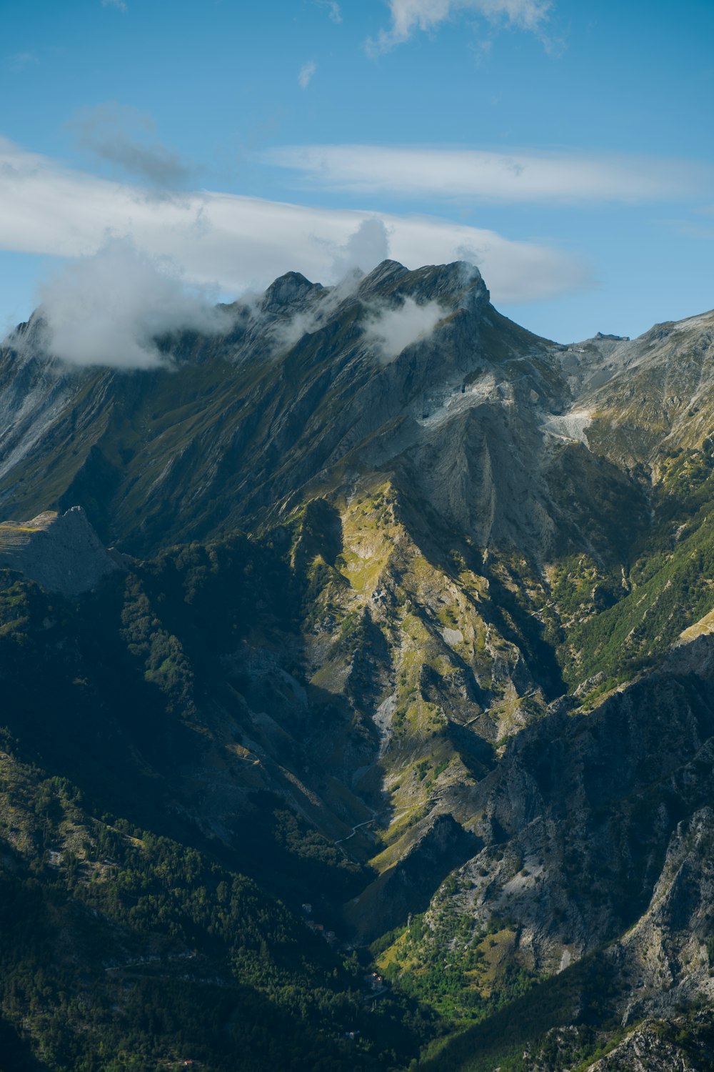 a view of a mountain range with a few clouds in the sky