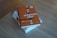A stack of books on a wooden surface, with the top book displaying a bold, orange cover featuring the title 'automate your busywork' in large white and black letters.