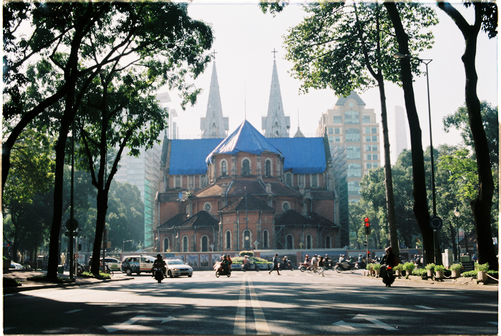 a large building with a blue roof surrounded by trees