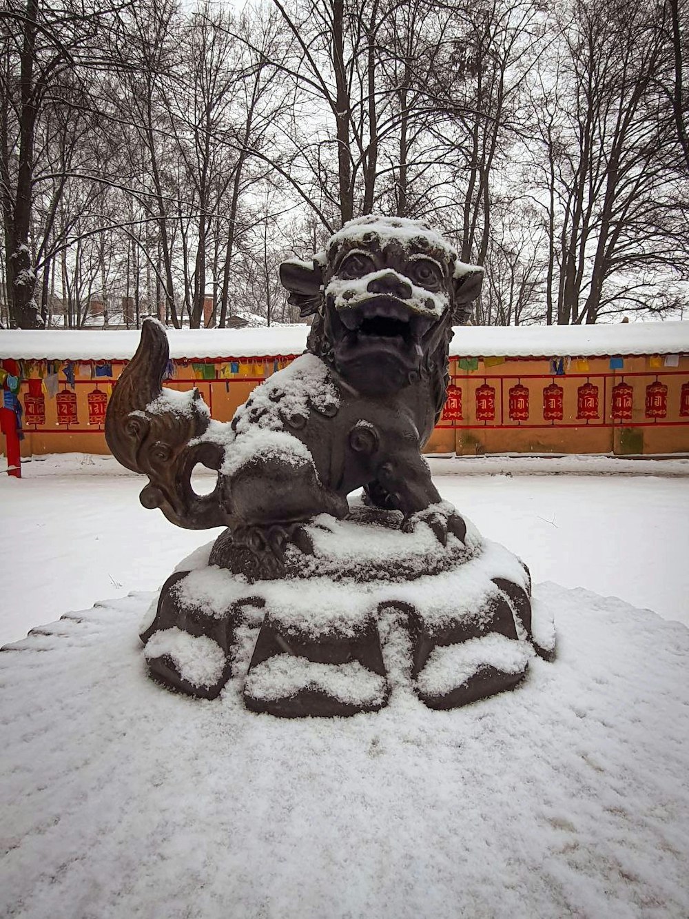 a statue of a lion is covered in snow