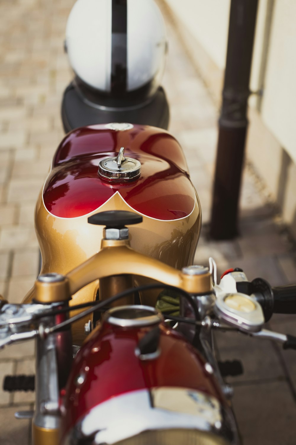 a red and gold motorcycle parked on a sidewalk