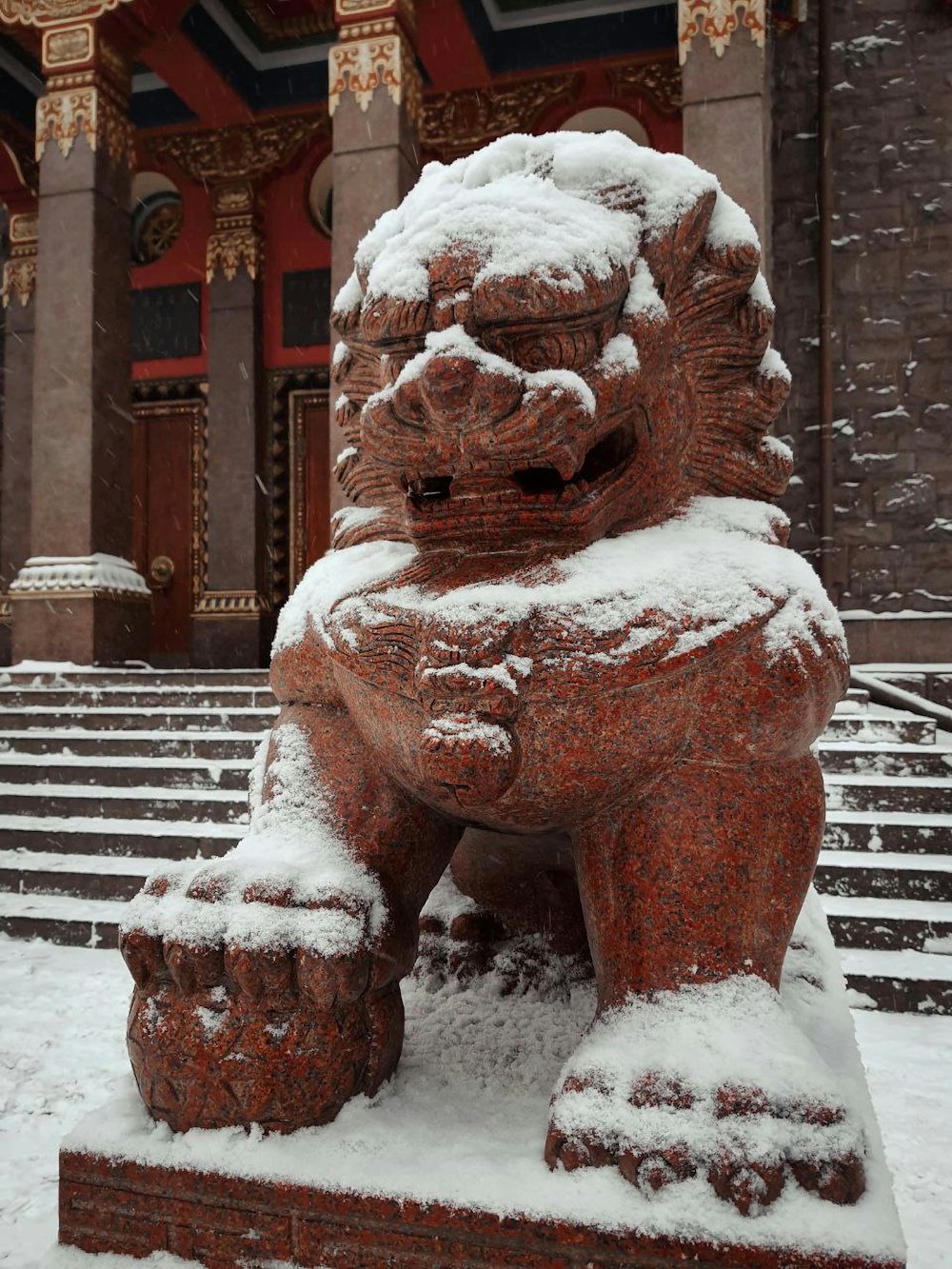 a statue of a lion is covered in snow