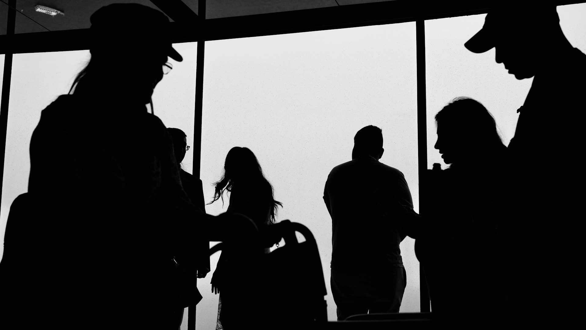 a group of people standing next to each other near a window