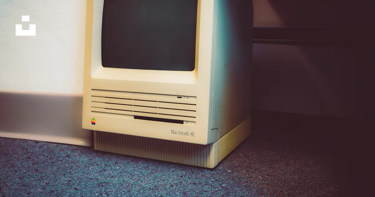 An old computer sitting on the floor next to a wall photo – Free ...