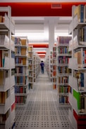 a man walking through a library filled with lots of books