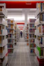 a man walking through a library filled with lots of books